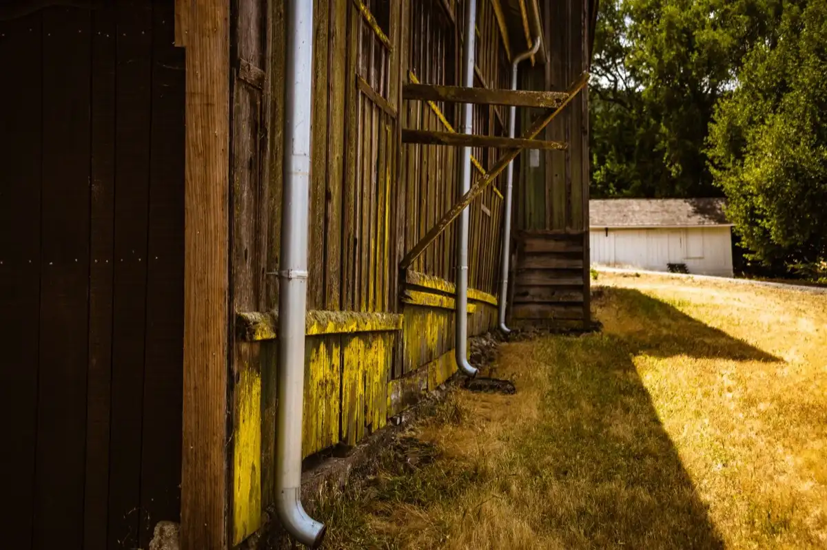 Roof edge, fascia and downspout on a house in Santa Clarita, CA, where drip edge carries runoff into the gutter